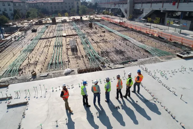 Site team in PPE reviewing a large construction site from above